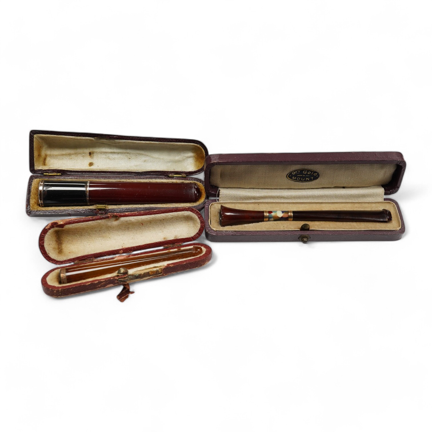 Three assorted cased cigarette holders, including amber, largest 10.1cm. Condition - fair